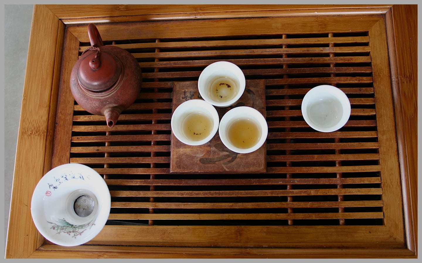 A Teochew-style gongfu tea set: a small brewing pot and tiny cups arranged on a tray for many short infusions.