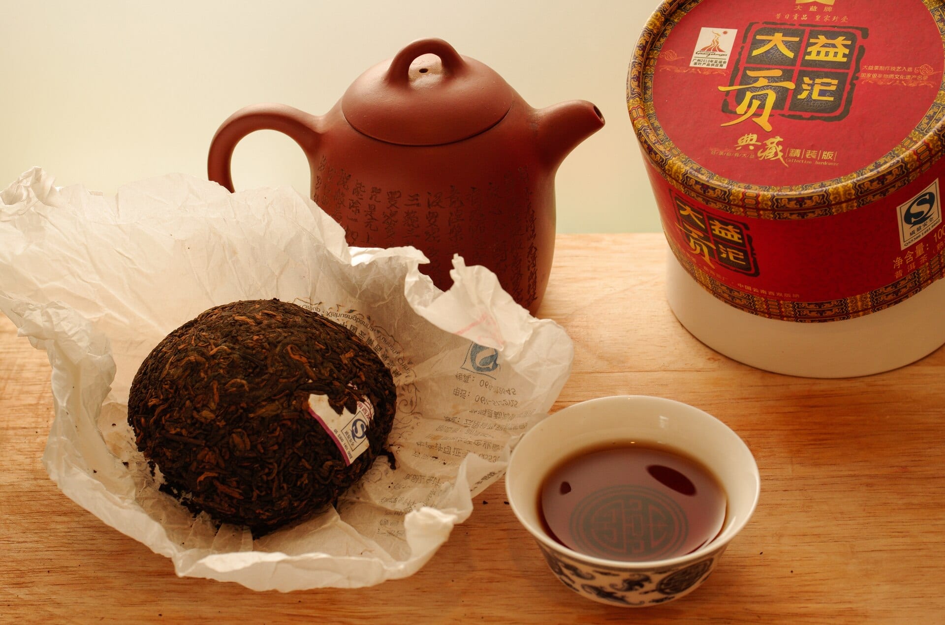A pressed ripe pu-erh tuocha, its dark leaves compacted into a domed bird's-nest shape.